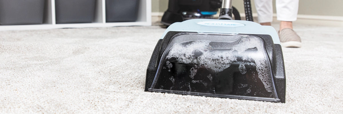 AquaMate on a carpet with a person cleaning in the background