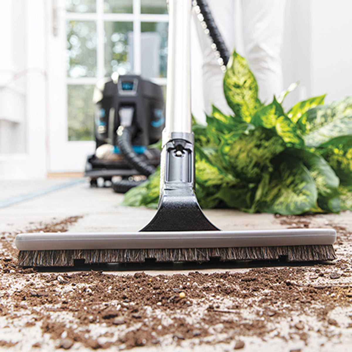 Floor Brush Attachment sucking up a spilled potted plant
